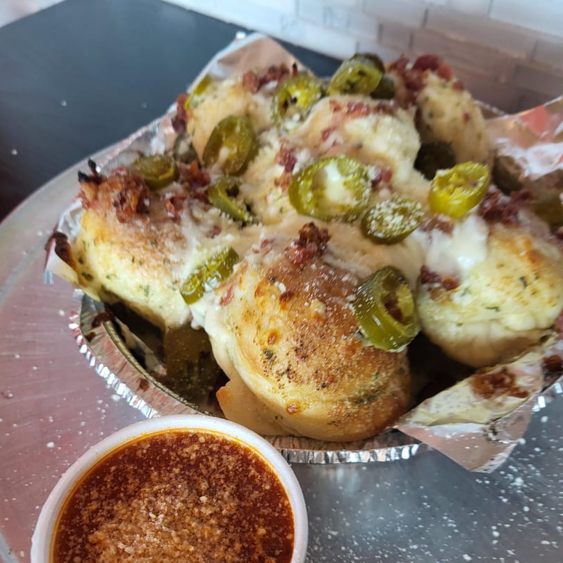Pana Roma Pizza & Pasta's cheesy garlic knots with jalapeños and bacon, served with marinara sauce.