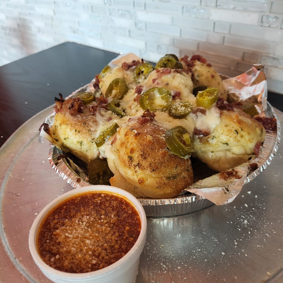 Pana Roma Pizza & Pasta's cheesy garlic knots with jalapeños and bacon, served with marinara sauce.