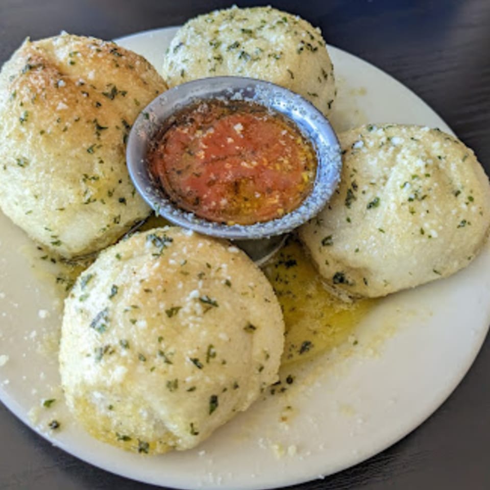 Pana Roma Pizza & Pasta garlic knots, sprinkled with herbs and cheese, served with marinara sauce.