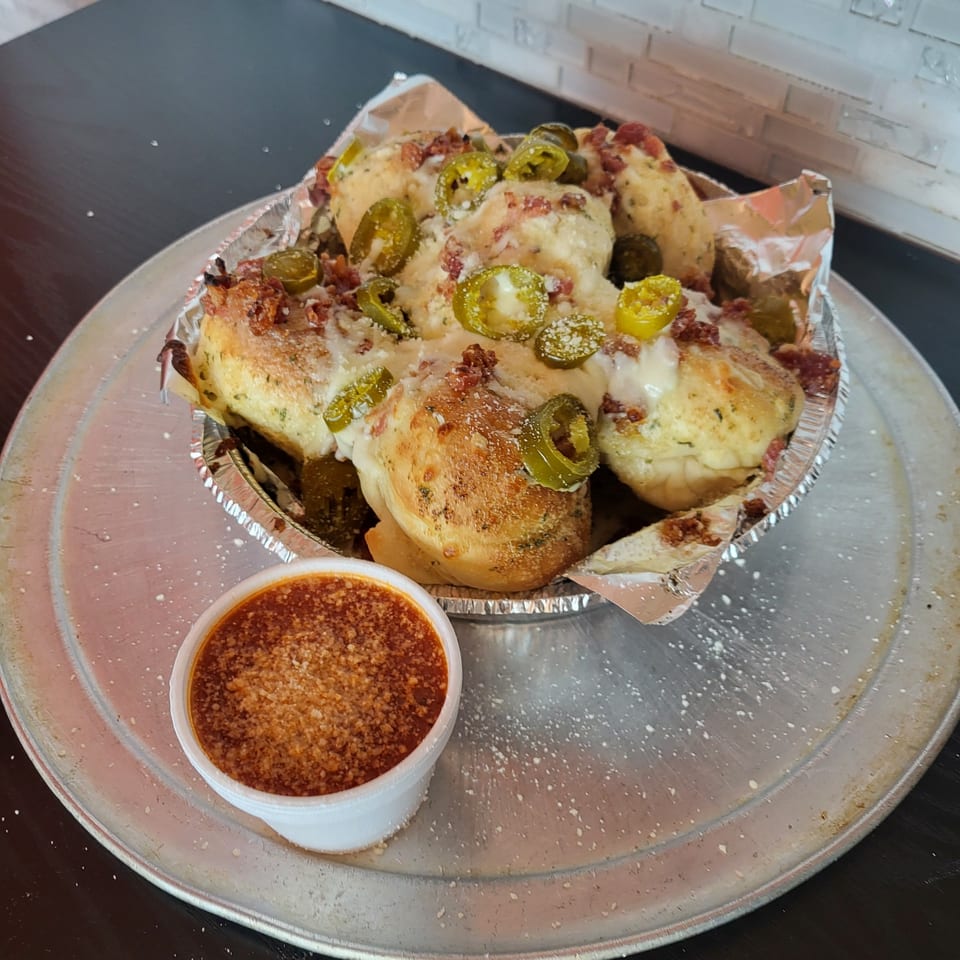 Pana Roma Pizza & Pasta's cheesy garlic knots with jalapeños and bacon, served with marinara sauce.